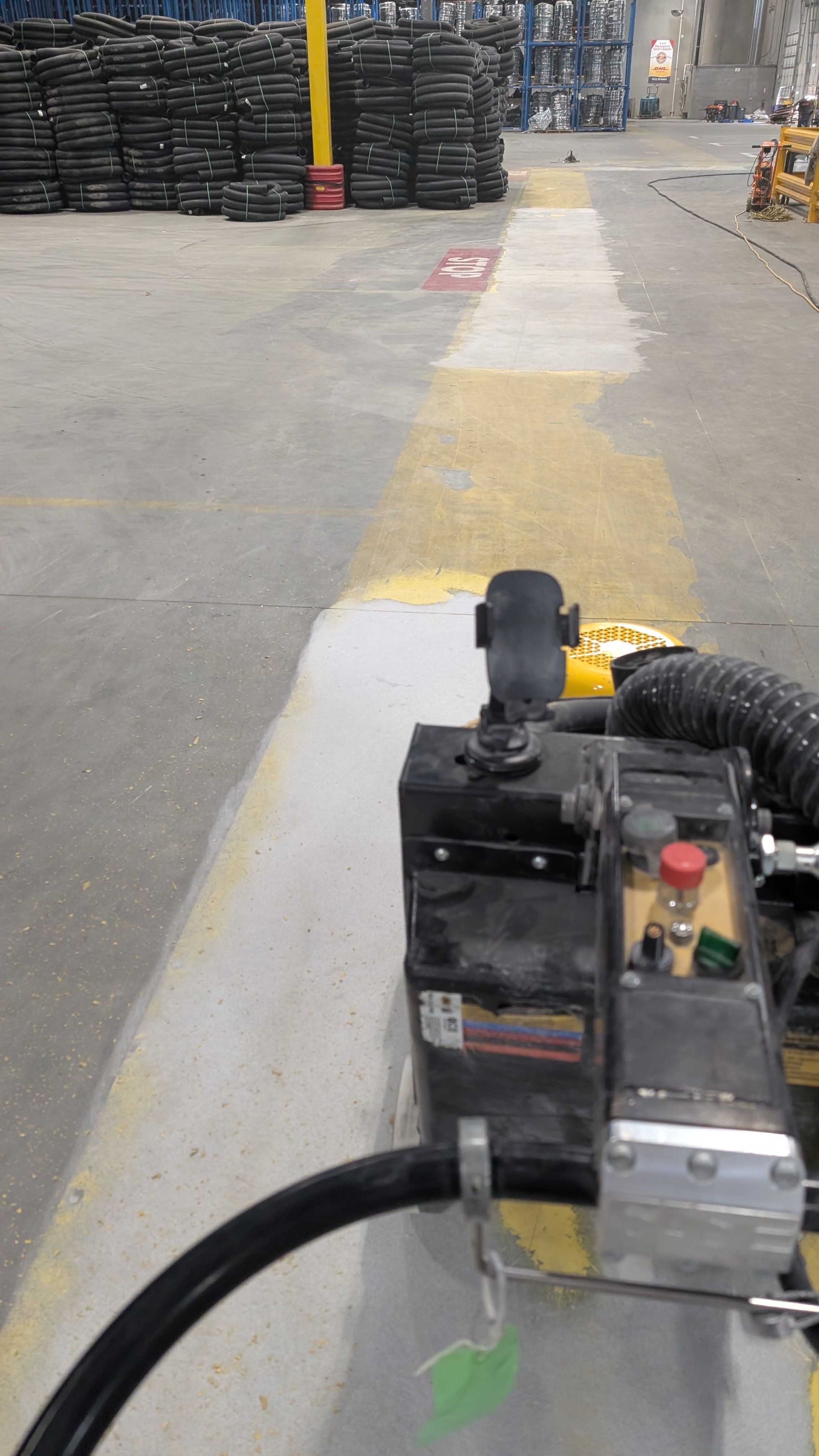 A machine is sitting on the side of a road in a warehouse.
