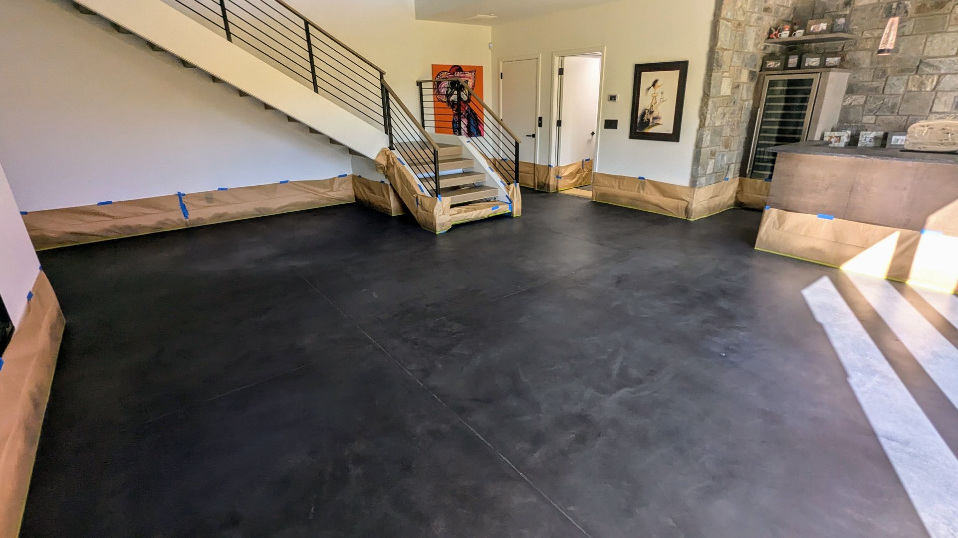 A large room with a staircase and a black floor.