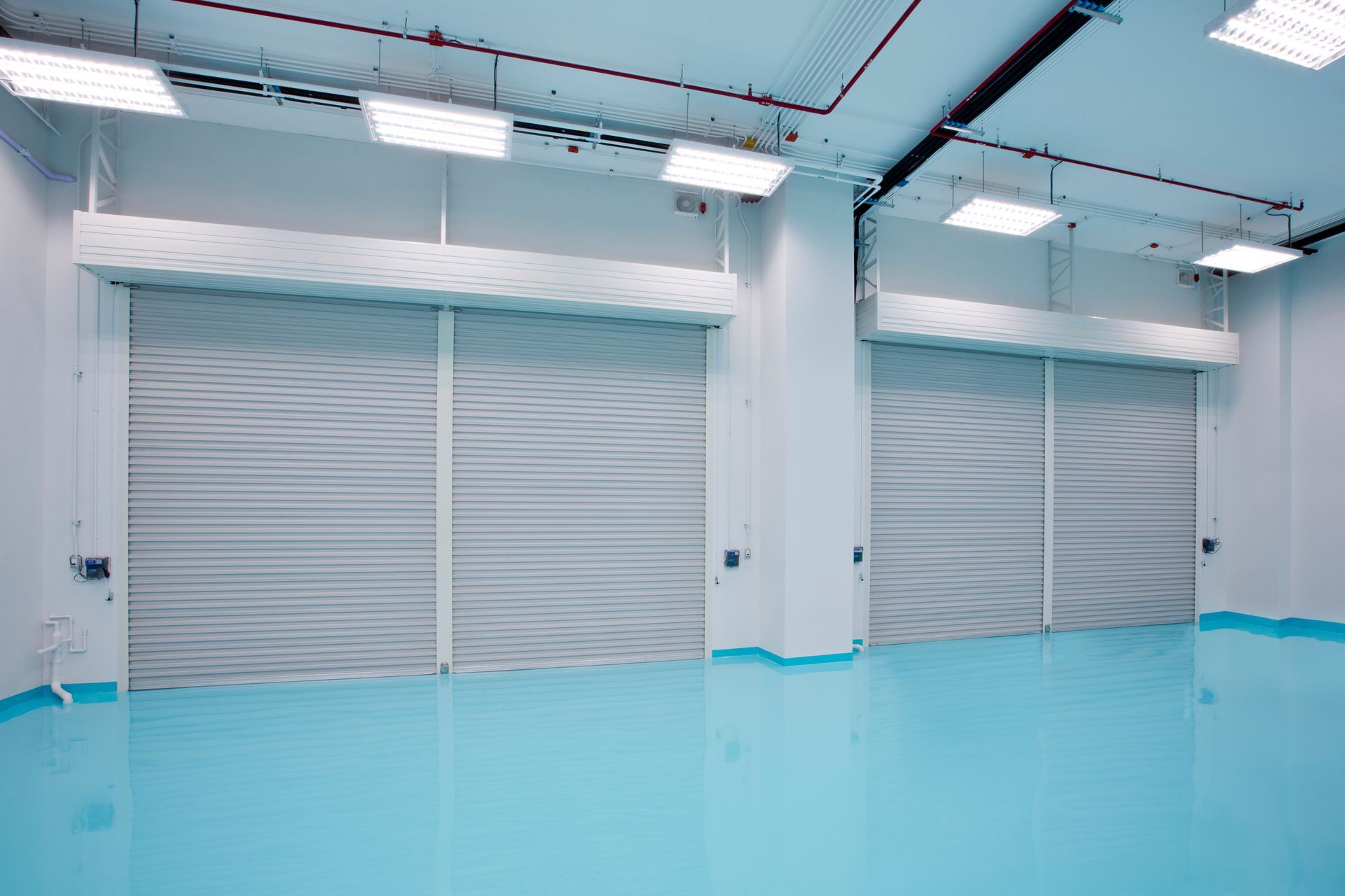A large empty room with a blue floor and white walls.
