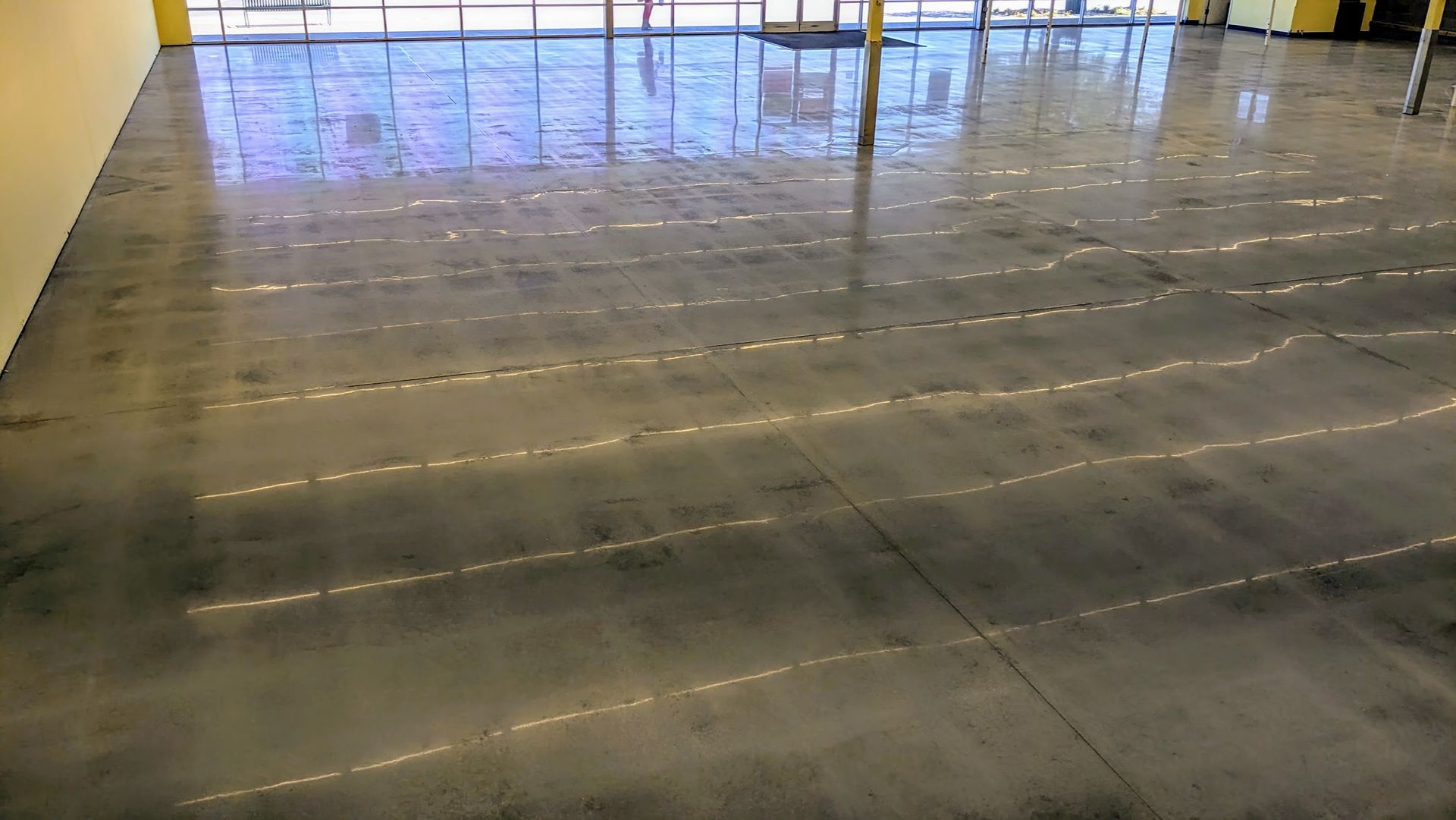 A shiny concrete floor in a large room with a lot of windows.