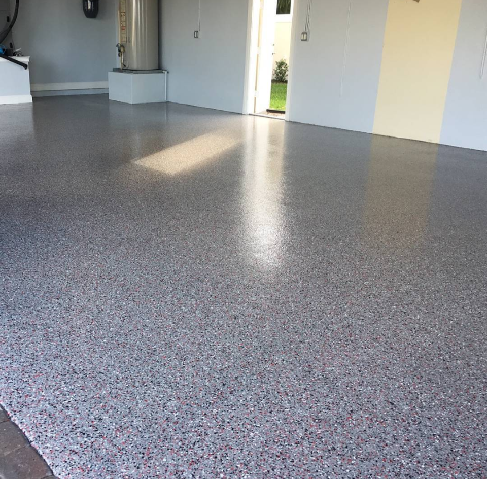 A dining room with a table and chairs and a shiny concrete floor