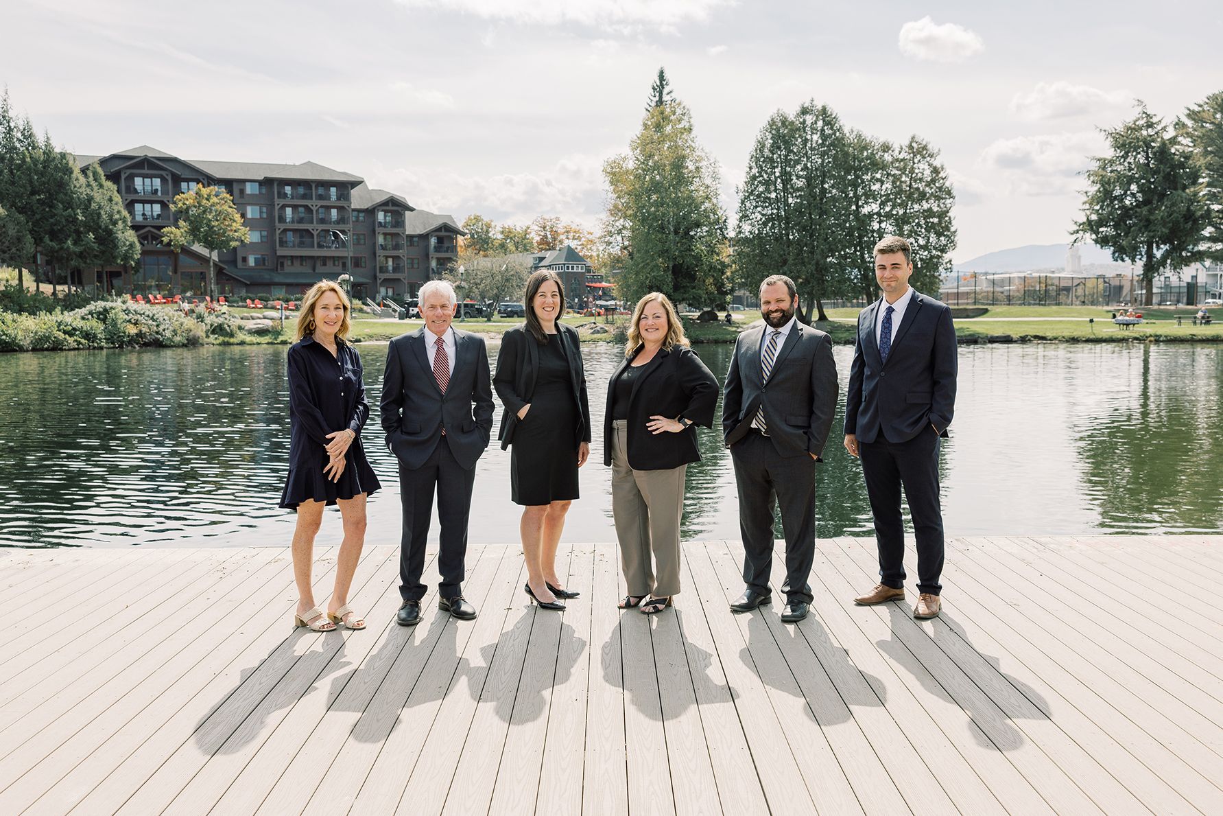 Attorneys at Flink Maswick Law in Lake Placid, NY standing in front of Mirror Lake.