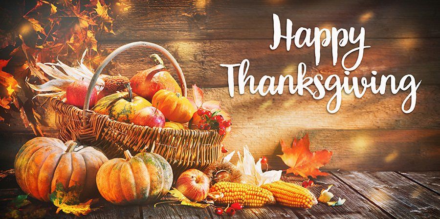 Happy Thanksgiving with basket of apples and gourds.  Pumpkins and dried corn on the table outside of the basket.
