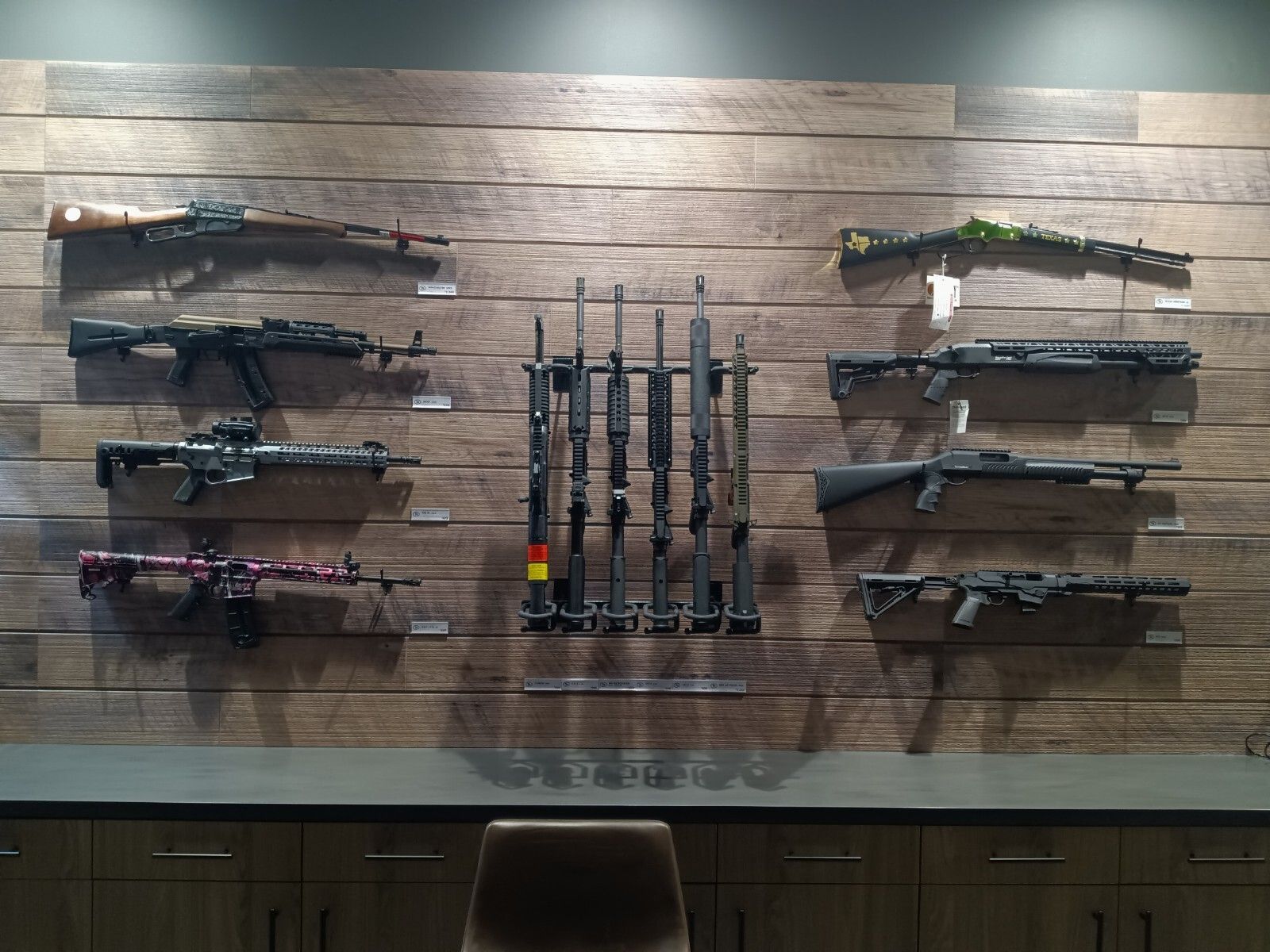 Rifles on a display wall at an indoor range in McKinney