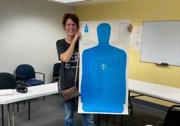 Instructor holding a blue silhouette training target in the classroom
