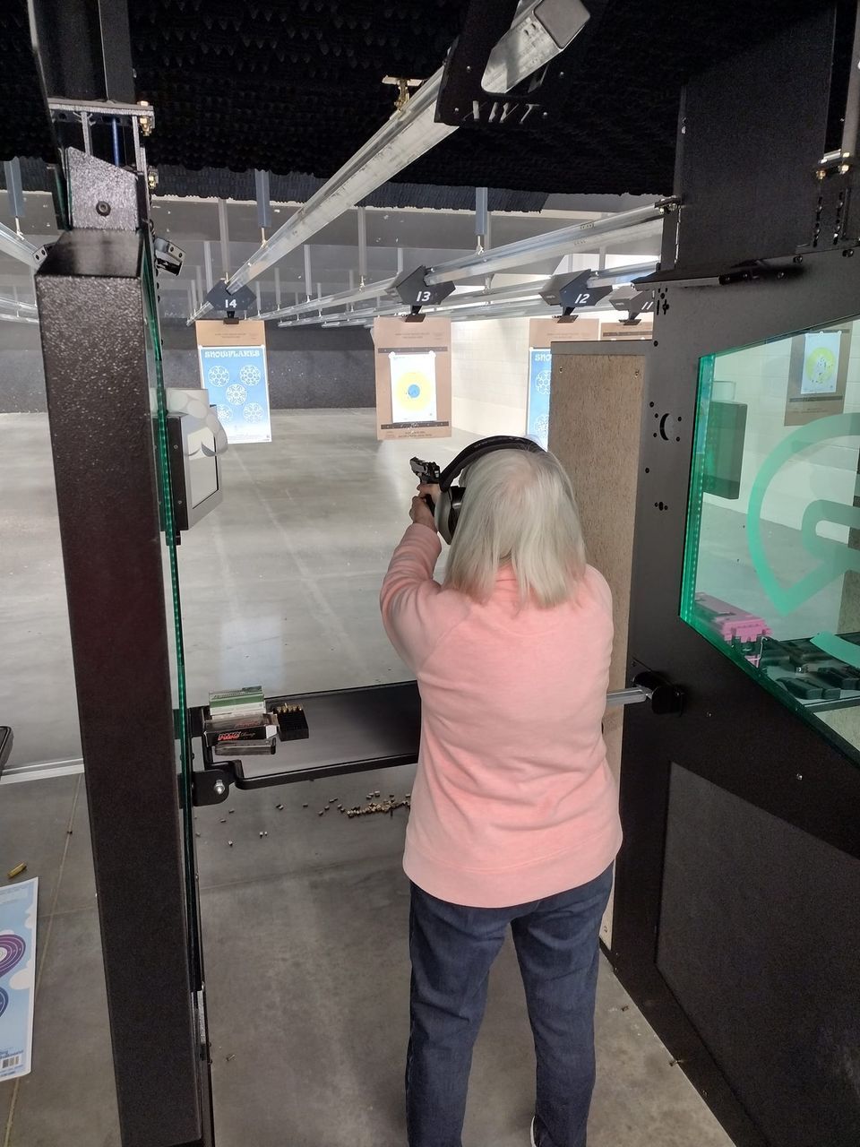 Woman shooting a pistol at an indoor lane