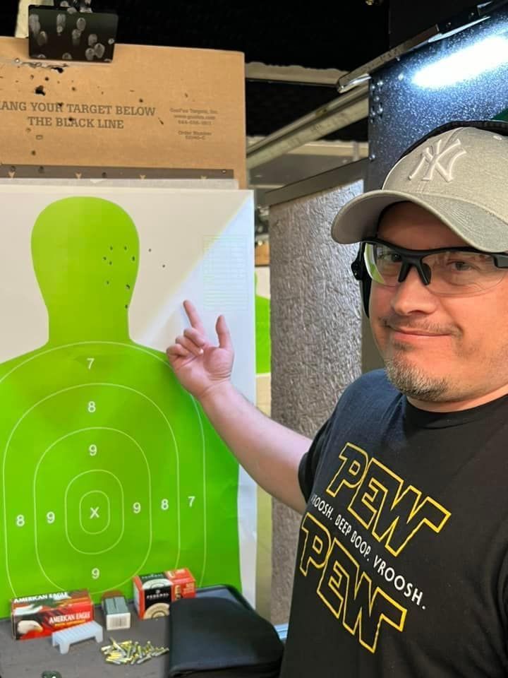 Man pointing to a silhouette target under green lighting