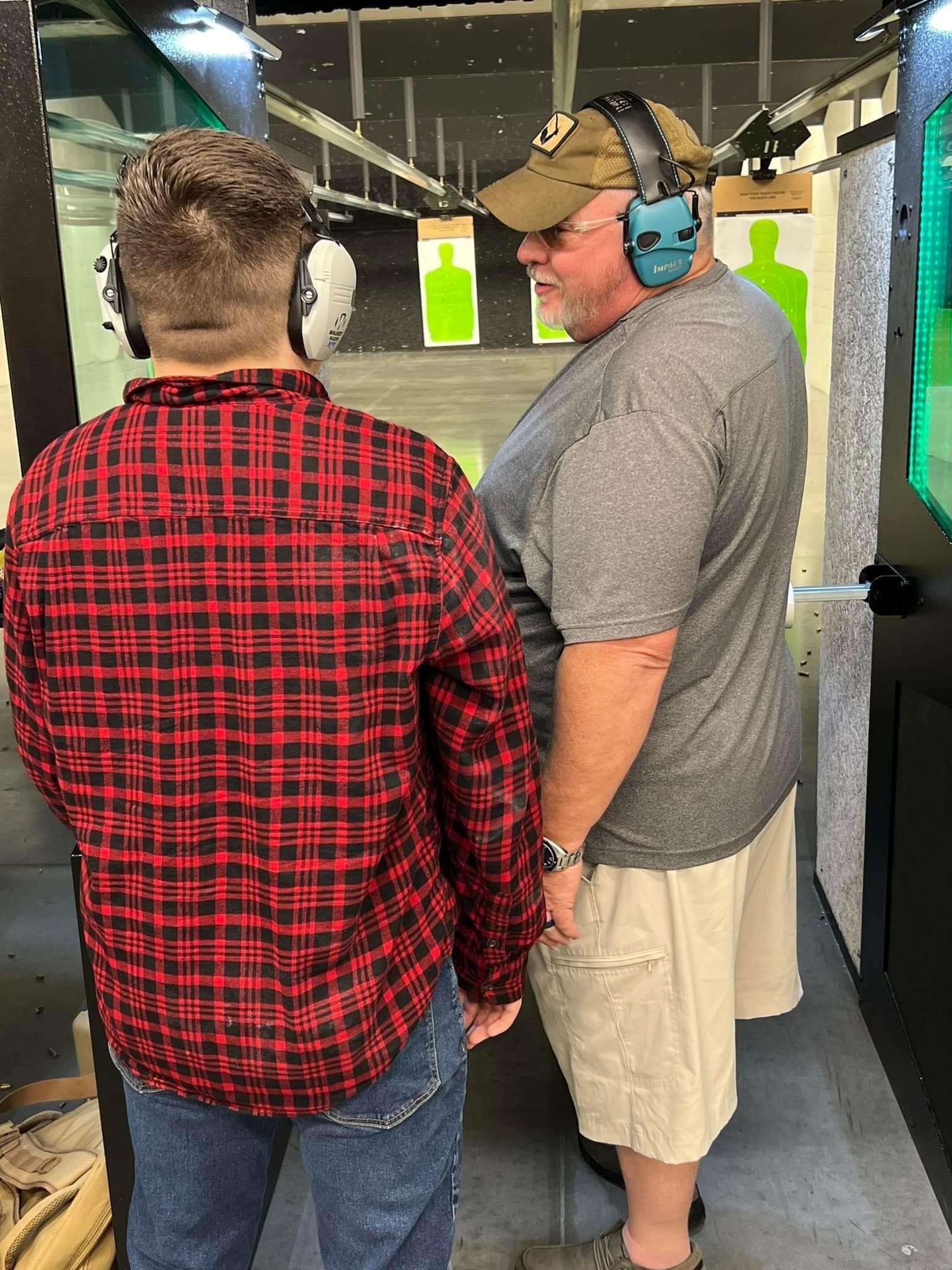 Instructor assisting a shooter at an indoor lane
