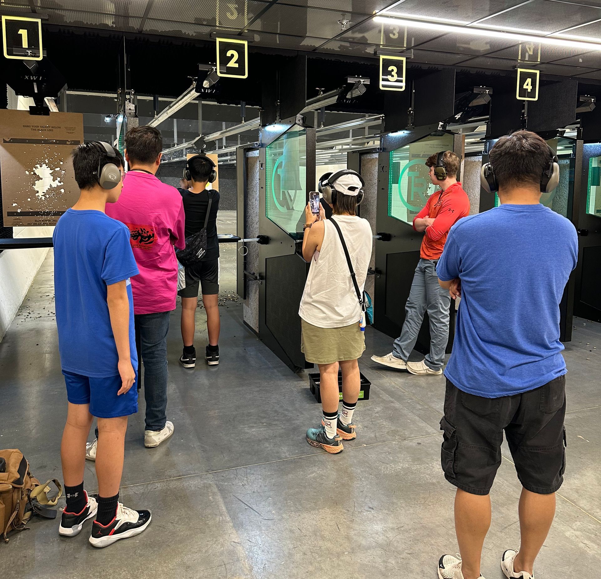 Group of young shooters at numbered indoor lanes
