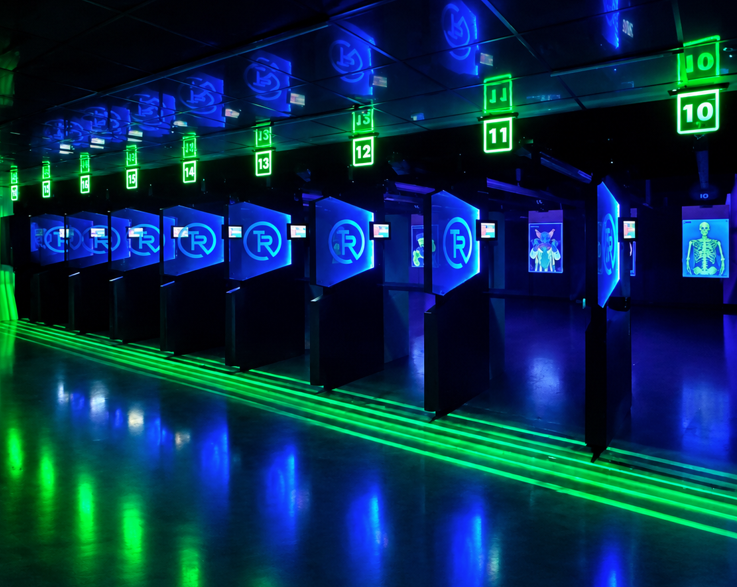 Indoor shooting range with lit lanes and numbered shooting stations