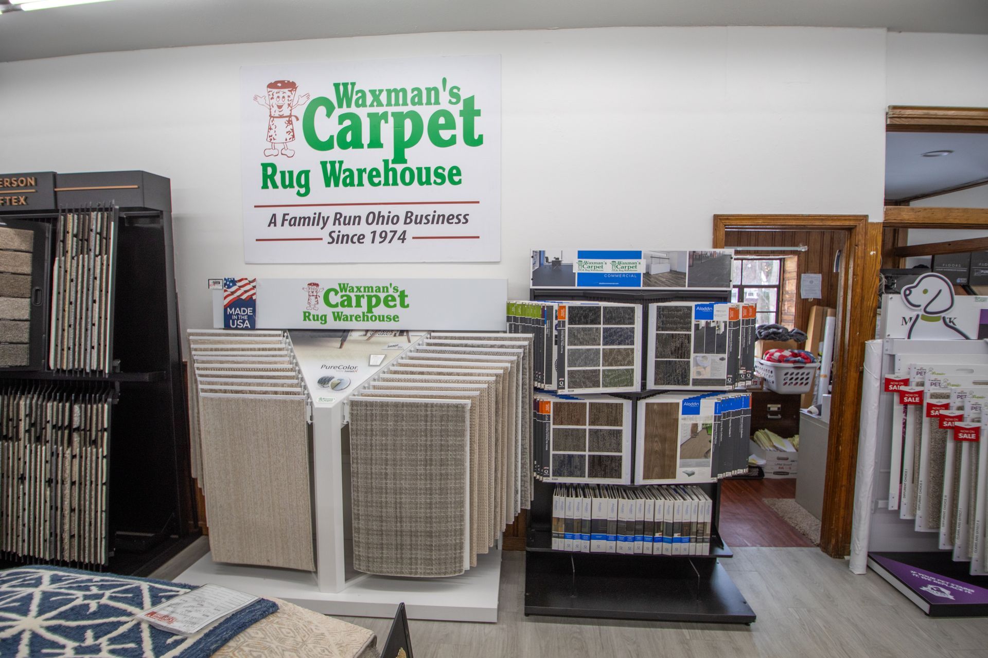 Interior of a carpet store with carpet samples on display. Signage reads 