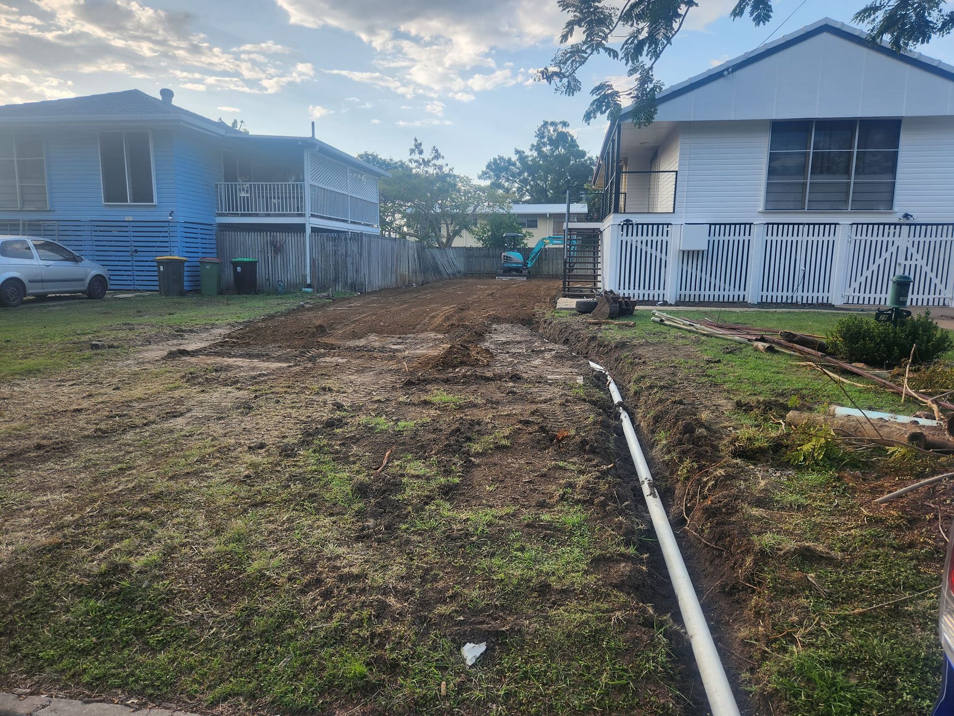 A Trench With White Pipe Runs Along the Grass, and Overcast Sky — AGM HIRE NQ in Kirwan, QLD