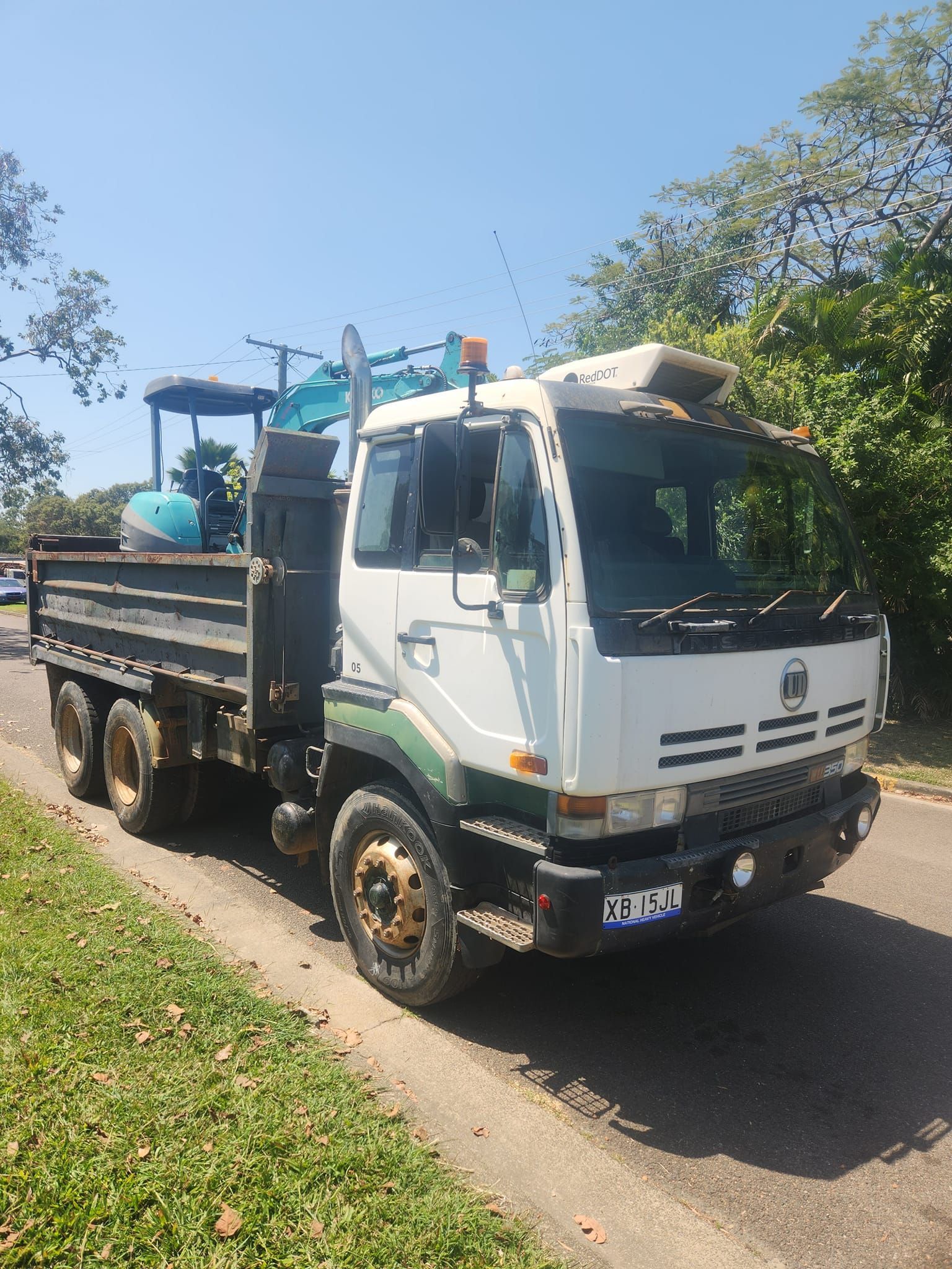 White and Green Dump Truck With Small Excavator — AGM HIRE NQ in Condon, QLD