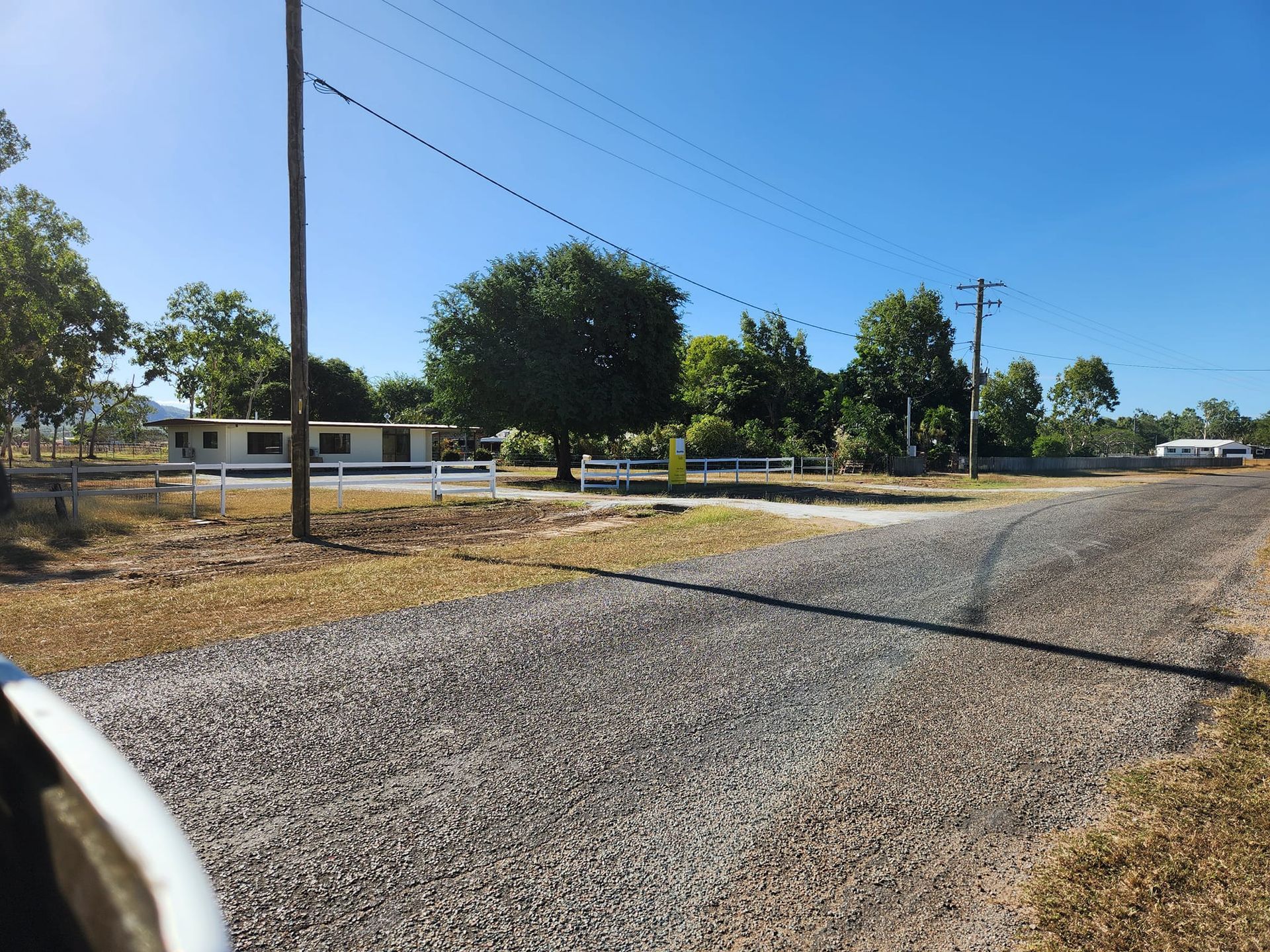 Gravel Road Leads to a Low Building With a Fence — AGM HIRE NQ in Condon, QLD