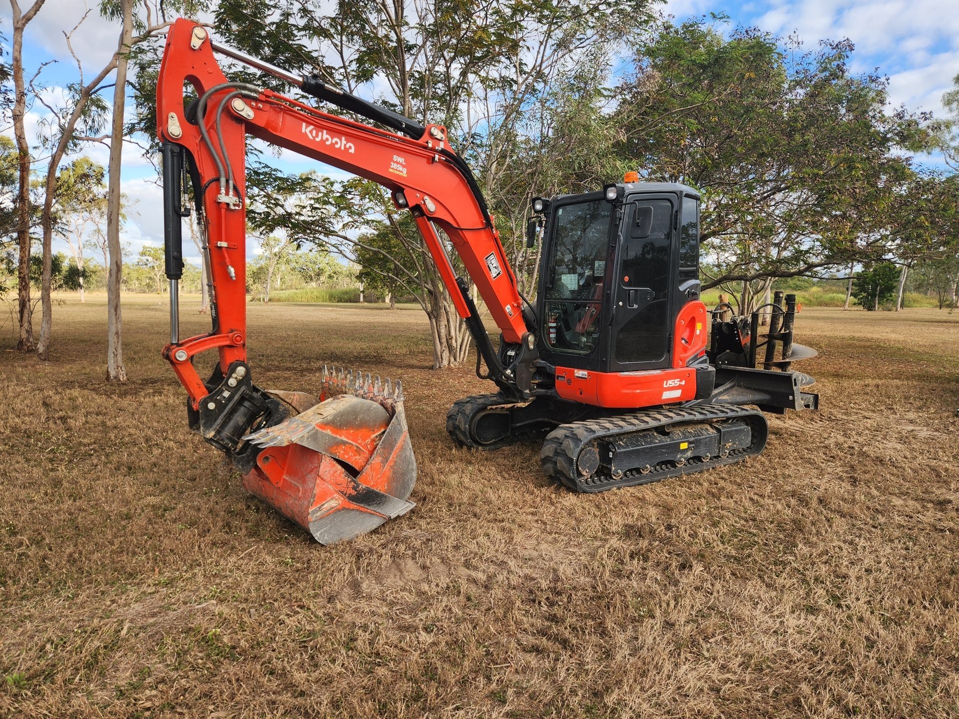 Red Kubota Excavator on Dry Grass Field — AGM HIRE NQ in Condon, QLD