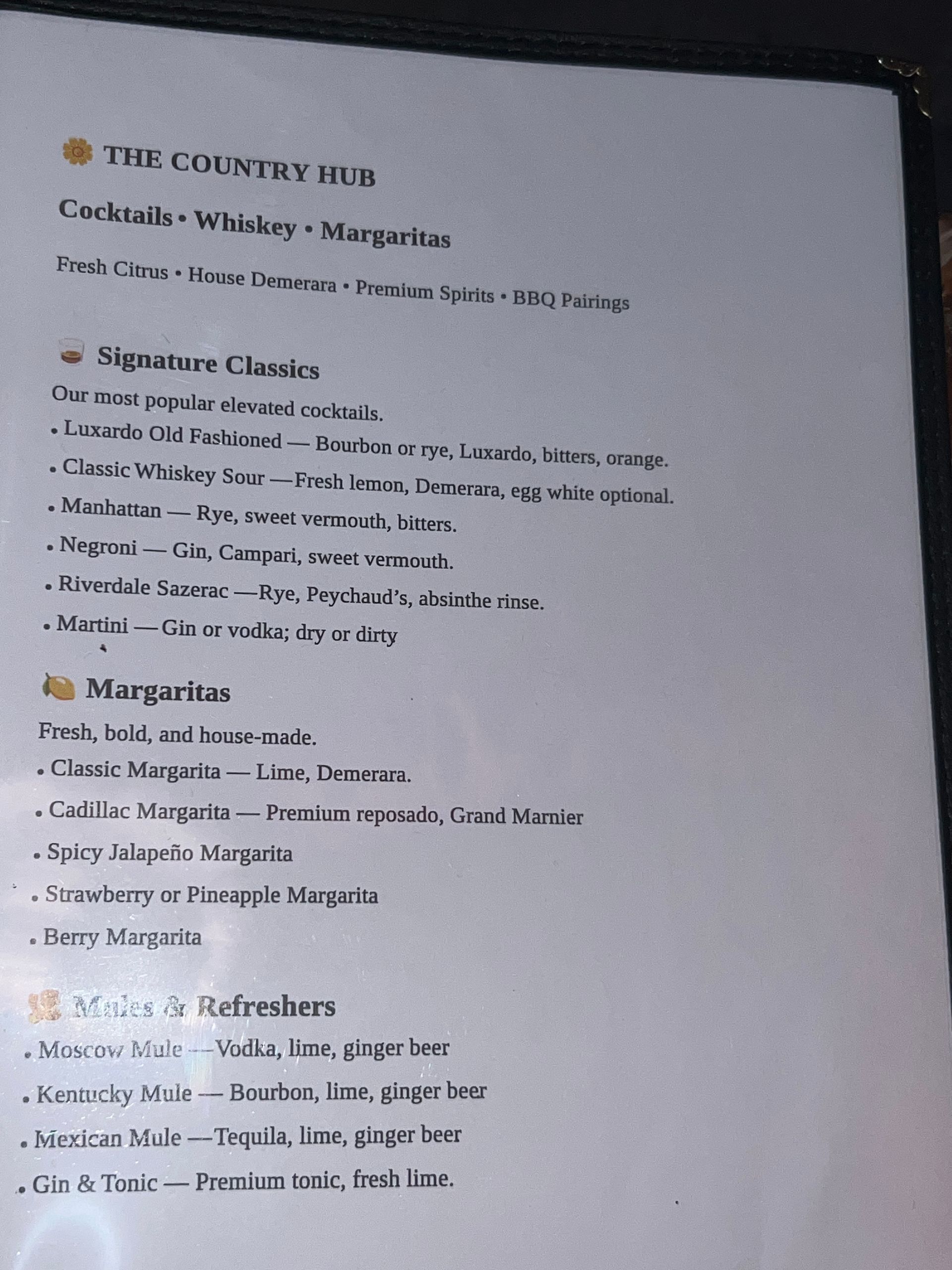 Blurry photo of a printed restaurant menu page with section headings and item lists.