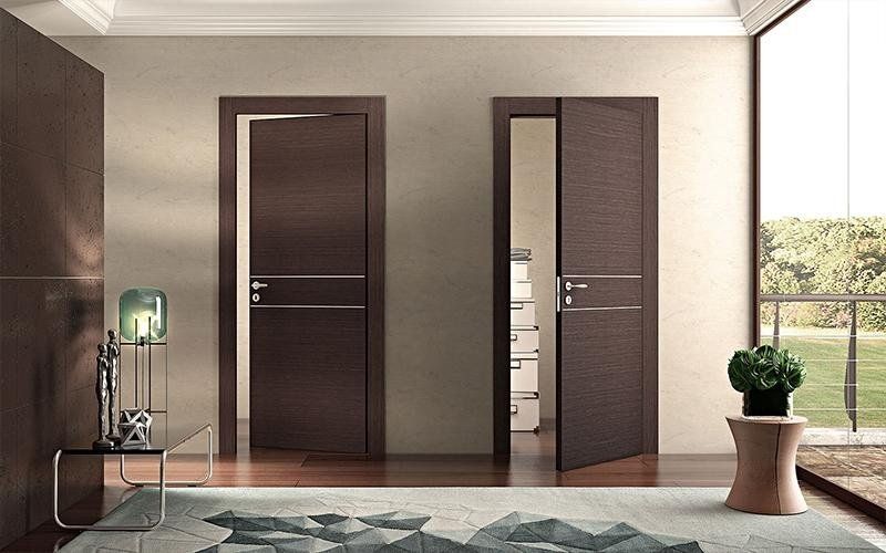 Un soggiorno con due porte marroni e un tappeto.