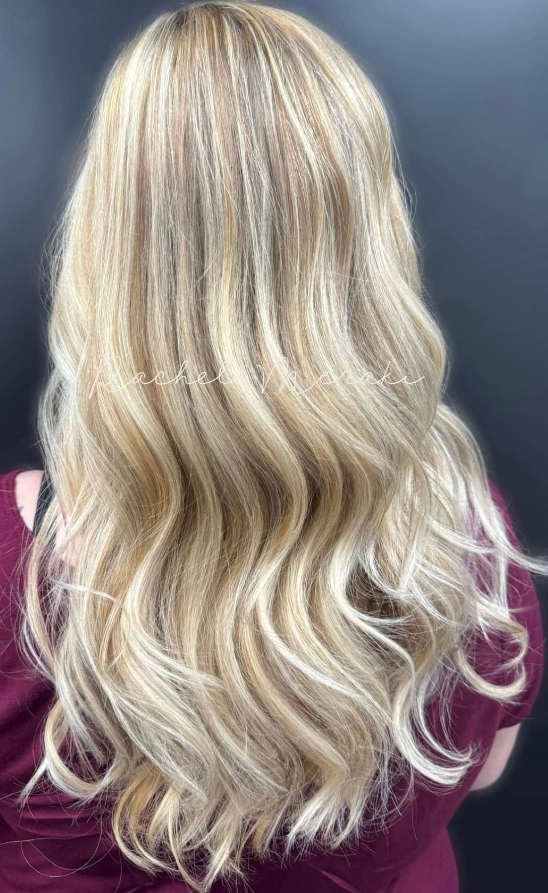 Wavy blonde hair with soft highlights, shown from the back on a dark background