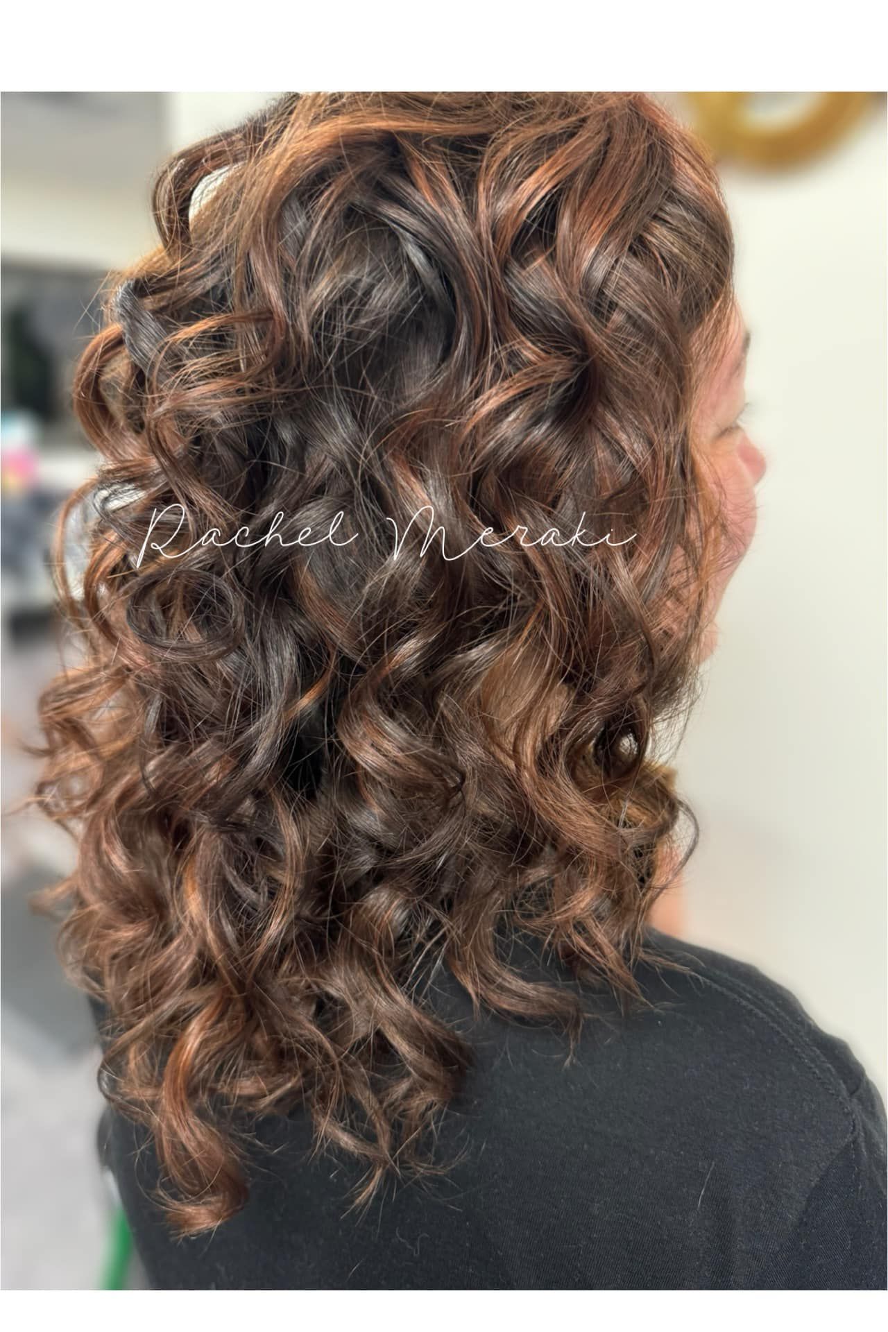 Curly brown-highlighted shoulder-length hairstyle viewed from the back and side.