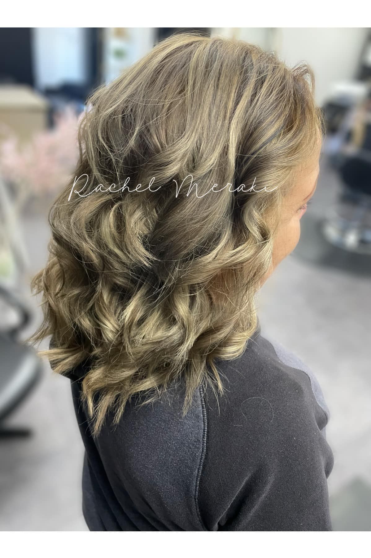 Wavy shoulder-length brown hair with blonde highlights, styled in a salon setting