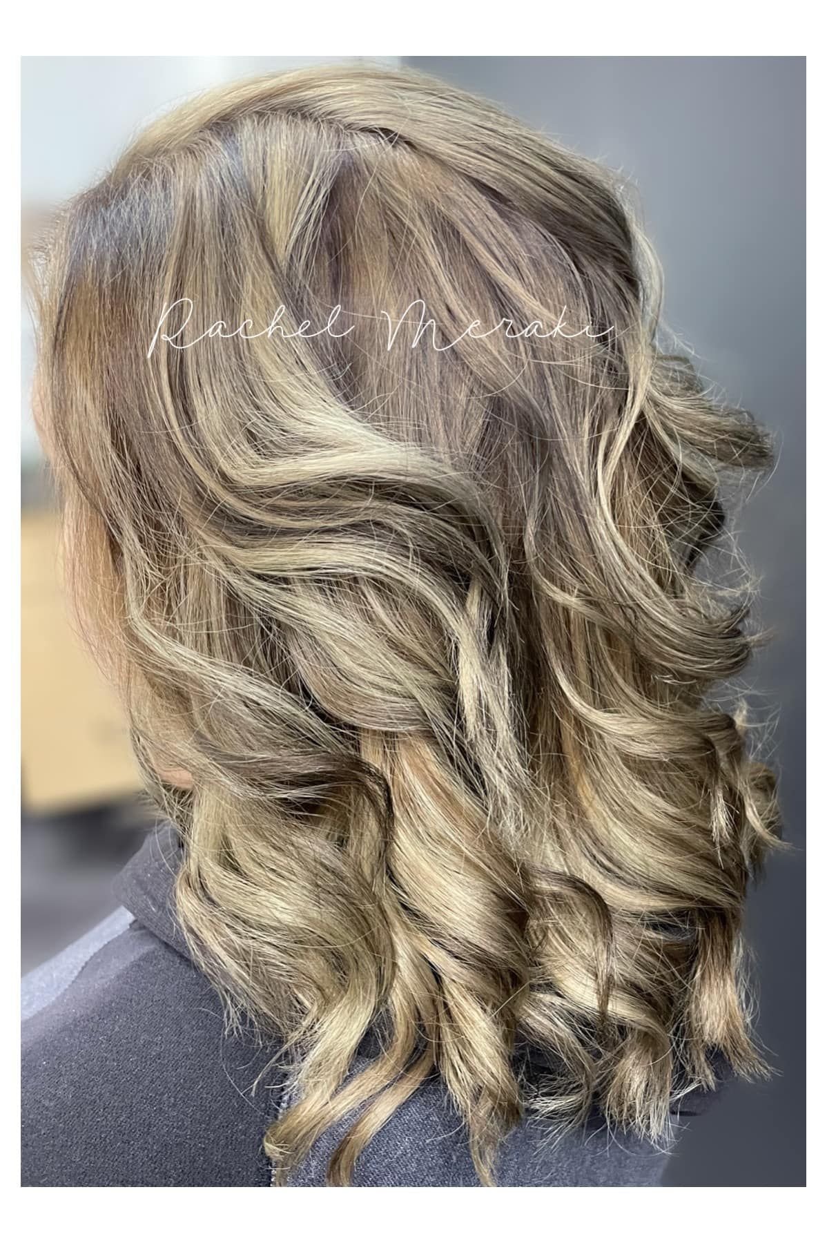 Layered shoulder-length wavy hair with blonde highlights and darker lowlights, shown from the back/side