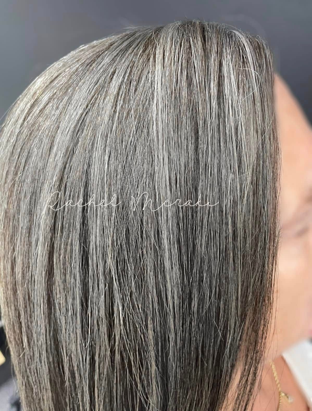 Close-up of silver-gray hair with a smooth, straight texture against a blurred background