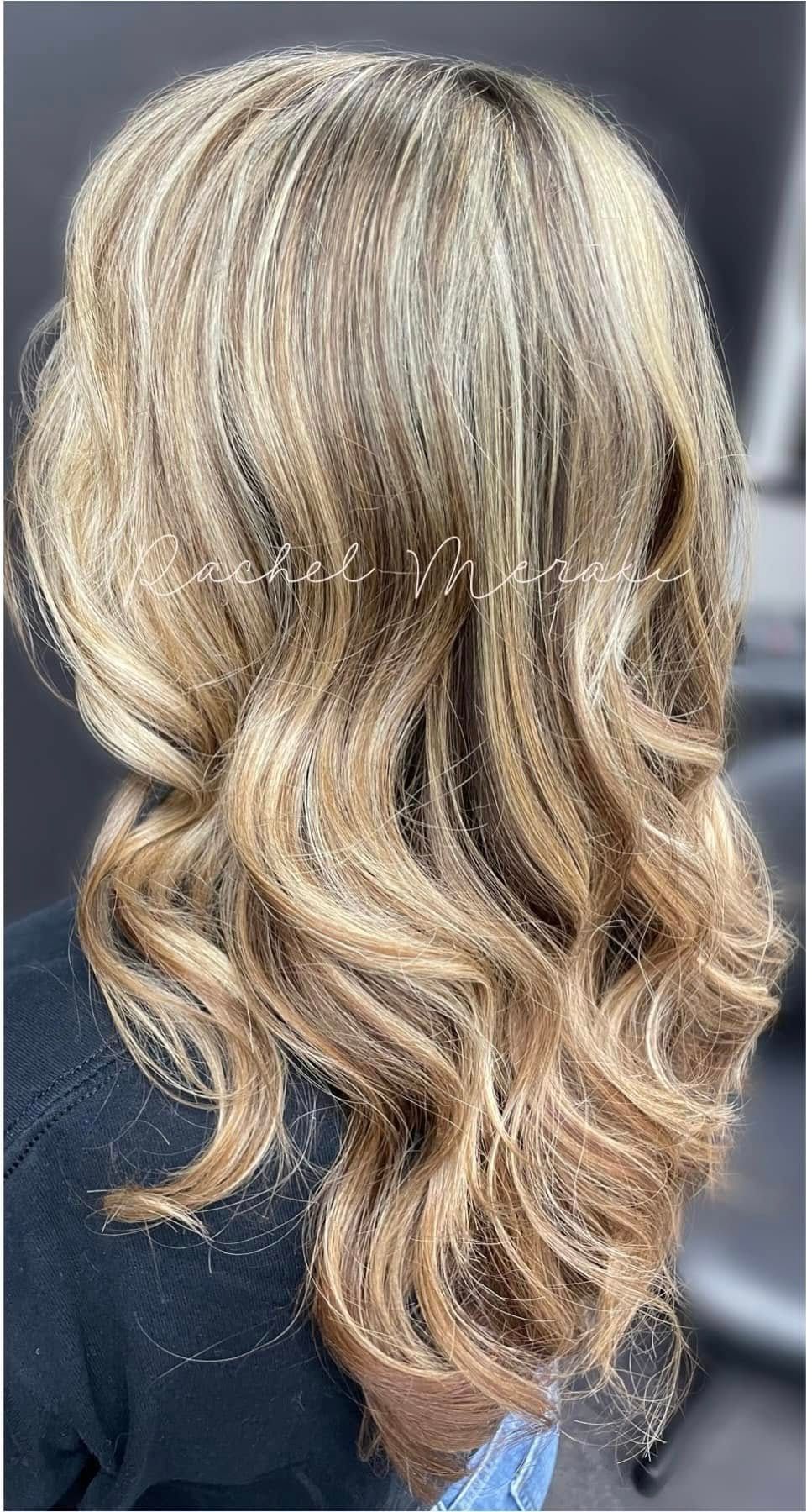 Blonde wavy layered haircut with subtle highlights, shown from the back against a dark background