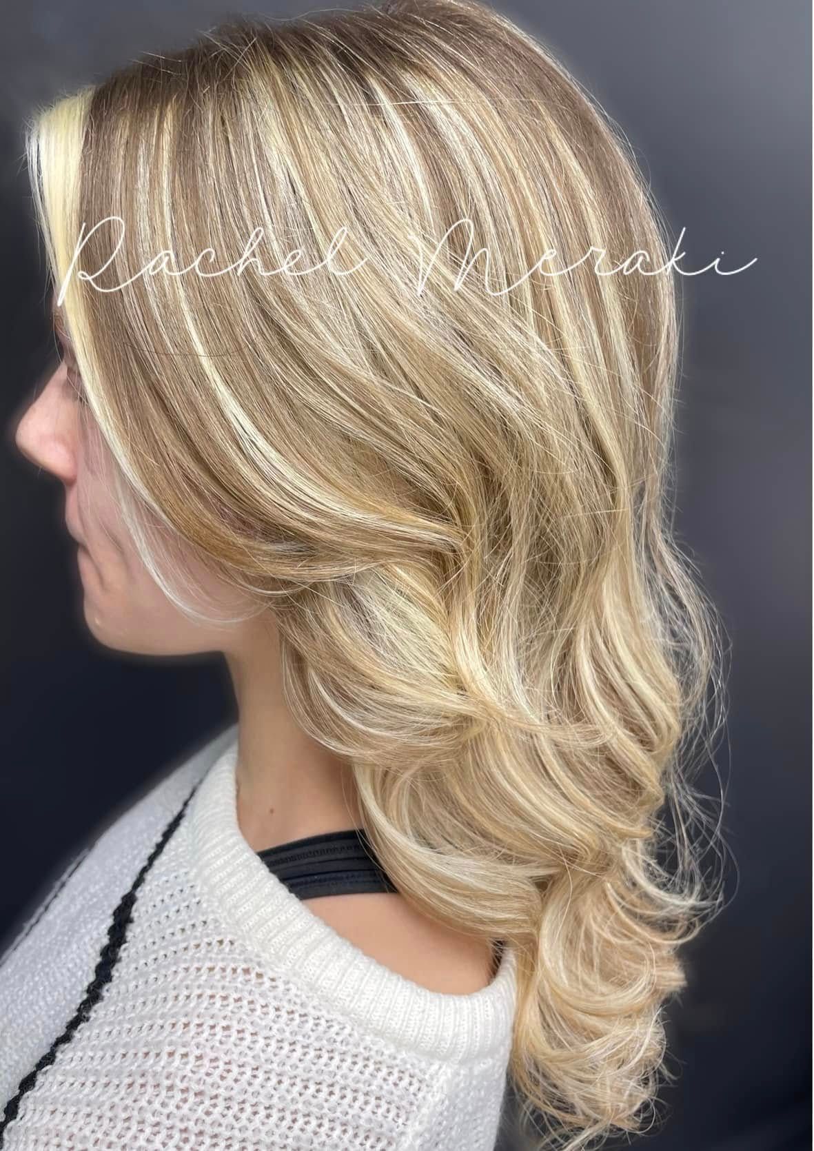 Side view of a shoulder-length blonde layered hairstyle with loose waves and curled ends.