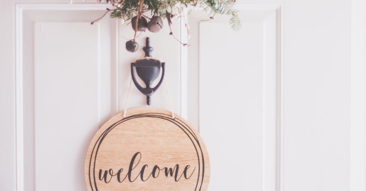 A welcome sign is hanging on a white door.