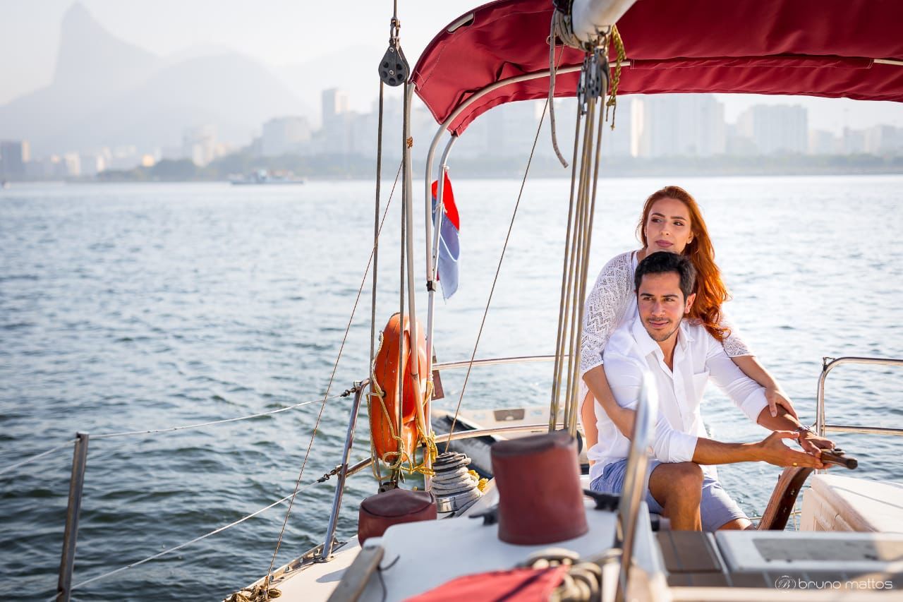Um homem e uma mulher estão sentados em um veleiro no oceano.