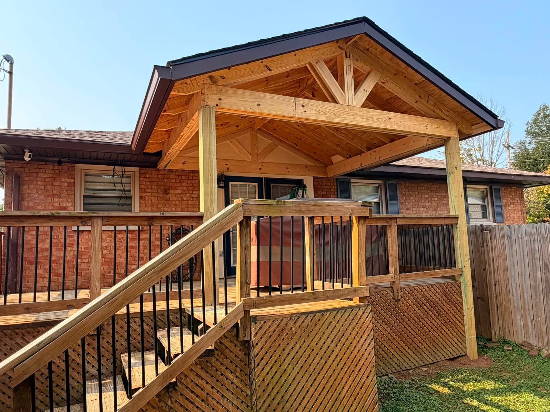 Wooden house with a covered porch and ramp-style deck railing in a rustic outdoor setting