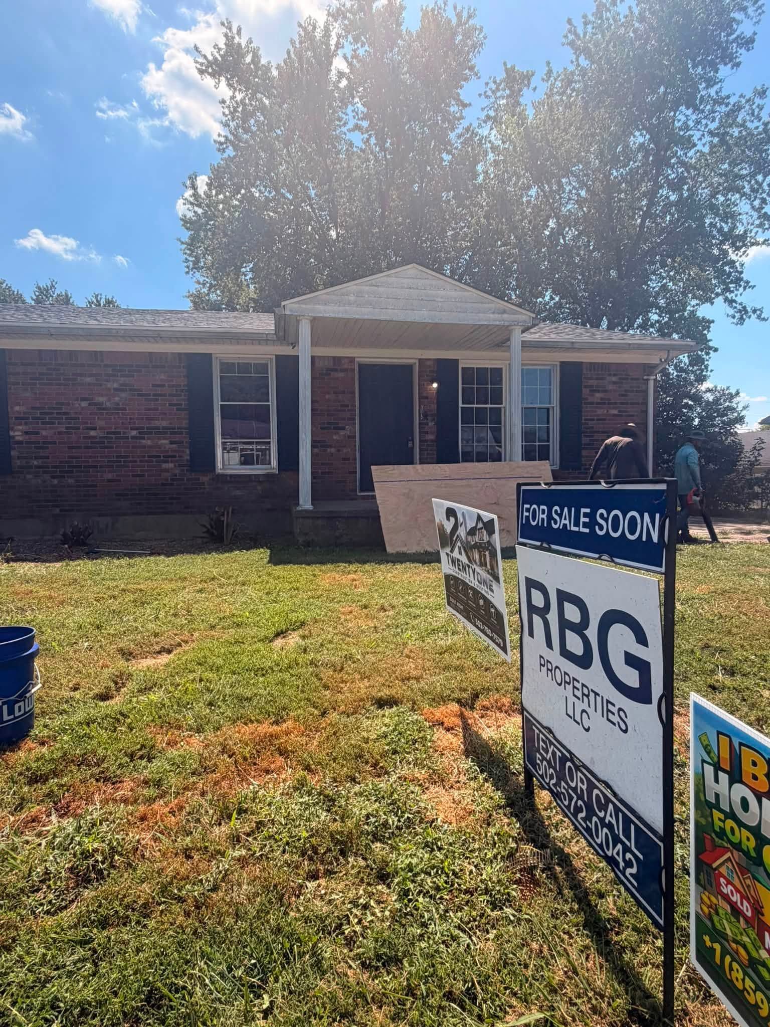 Brick house with RBG campaign signs on the front lawn in bright sunlight