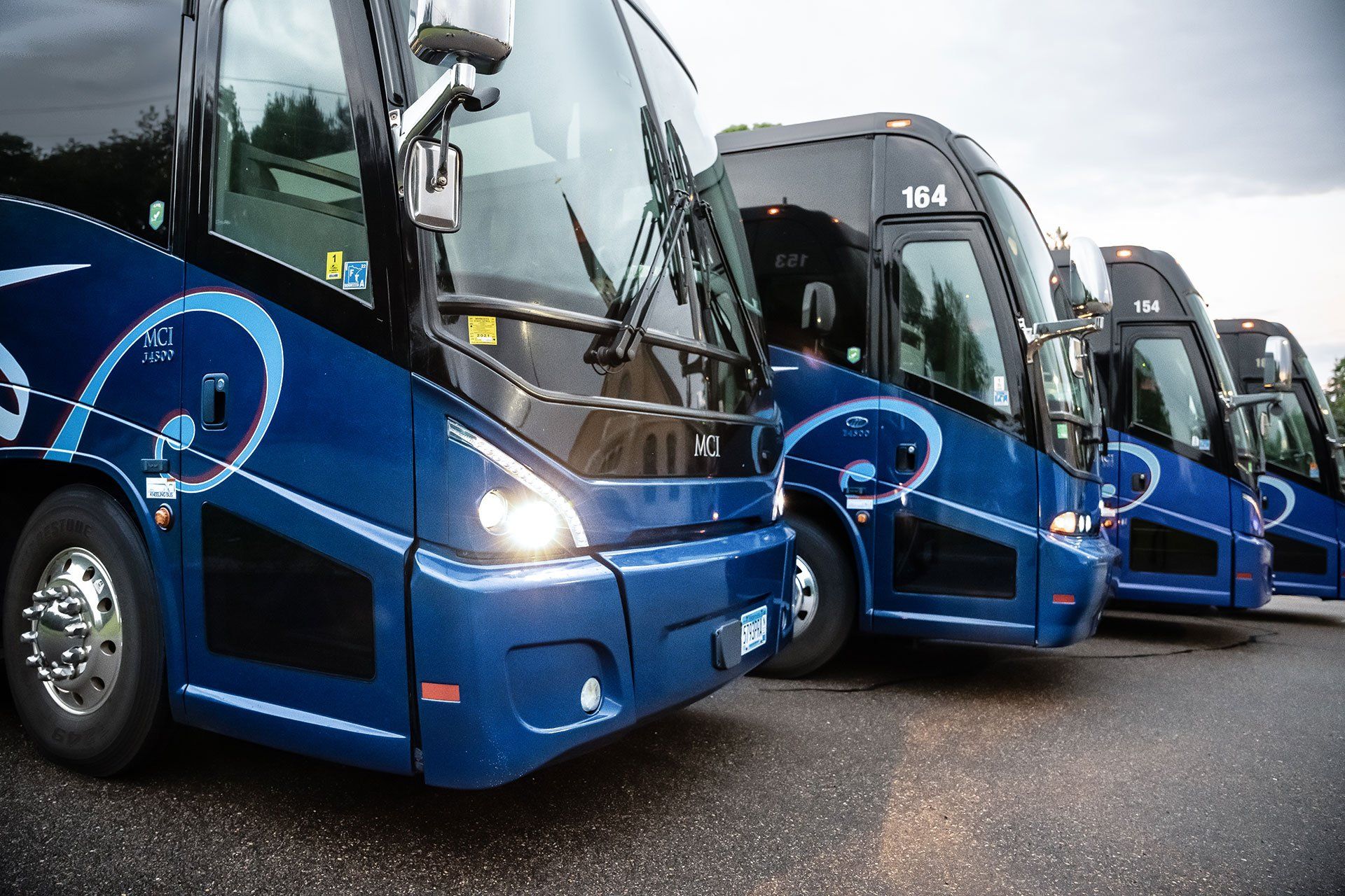 A Row of Blue 38-Passenger Deluxe Motor Coaches Lined Up in a Parking Lot in St. Cloud, MN