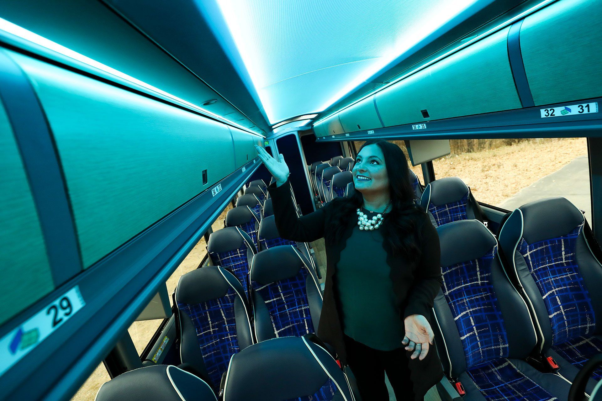A woman is showcasing the interior and features of a deluxe motor coach in Minneapolis-St. Paul
