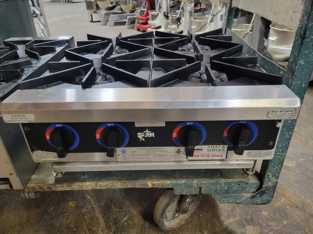 A gas stove is sitting on top of a cart.