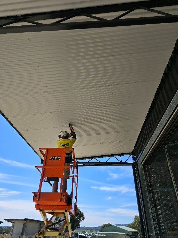 A Person Is Working on A Ceiling Under a Metal Structure — One Group Industries Pty Ltd in Bathurst, NSW