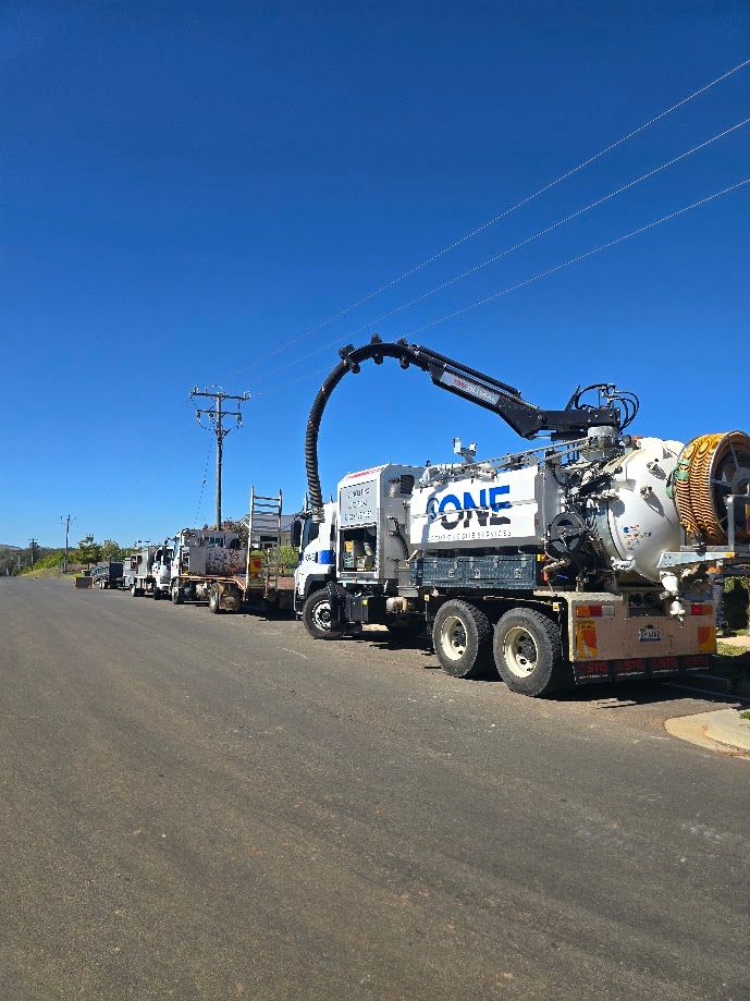A Row of Large White Trucks with Tanks and Hoses Parked on A Road — One Group Industries Pty Ltd in Bathurst, NSW