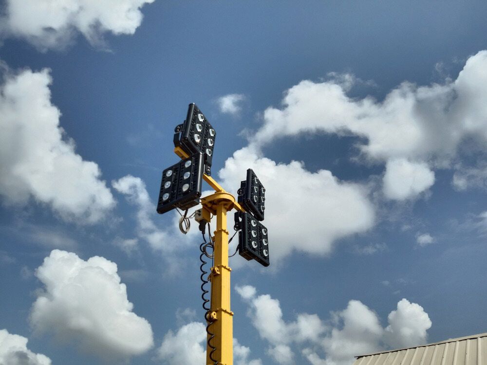 A Yellow Pole With a Bunch of Lights on It Against a Cloudy Sky — One Group Industries Pty Ltd in Bathurst, NSW