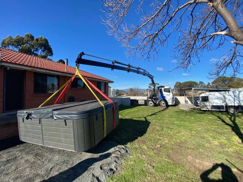 A Crane is Lifting a Hot Tub Into a House — One Group Industries Pty Ltd in Bathurst, NSW
