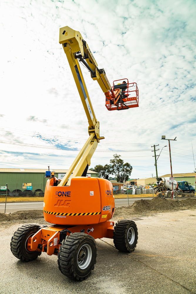 An Orange Jlg Lift is Parked on the Side of the Road — One Group Industries Pty Ltd in Bathurst, NSW
