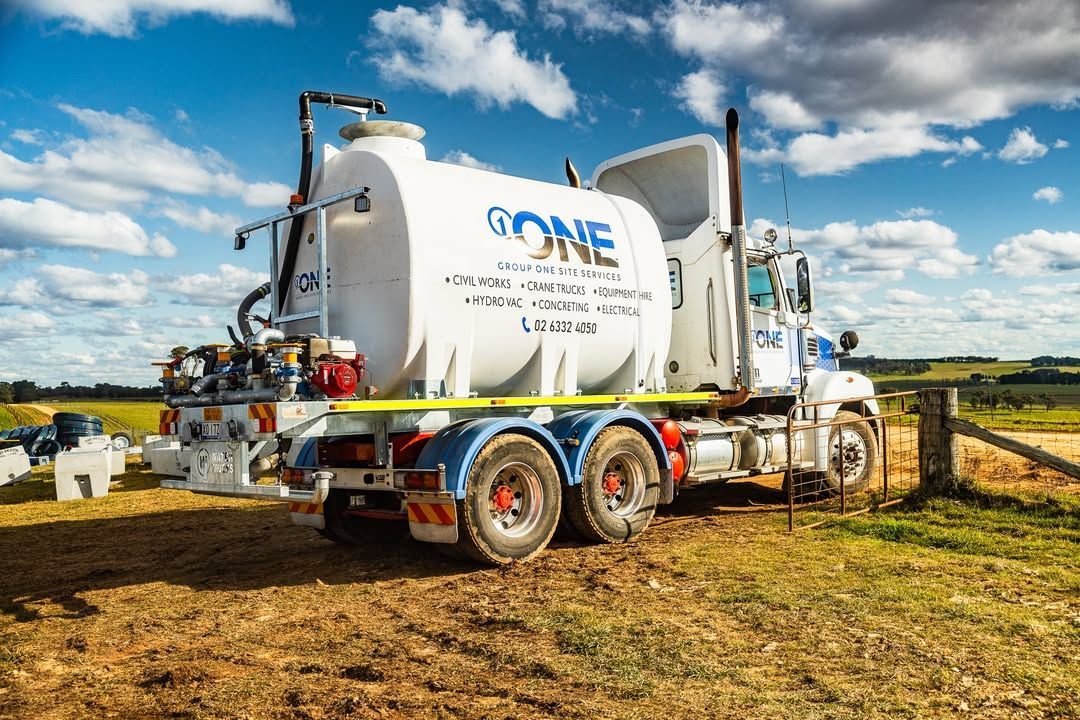 A White Tanker Truck Parked on A Grassy Field — One Group Industries Pty Ltd in Bathurst, NSW