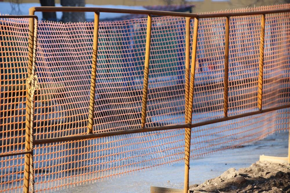 A Close Up of a Fence With a Wooden Railing on a Construction Site — One Group Industries Pty Ltd in Bathurst, NSW
