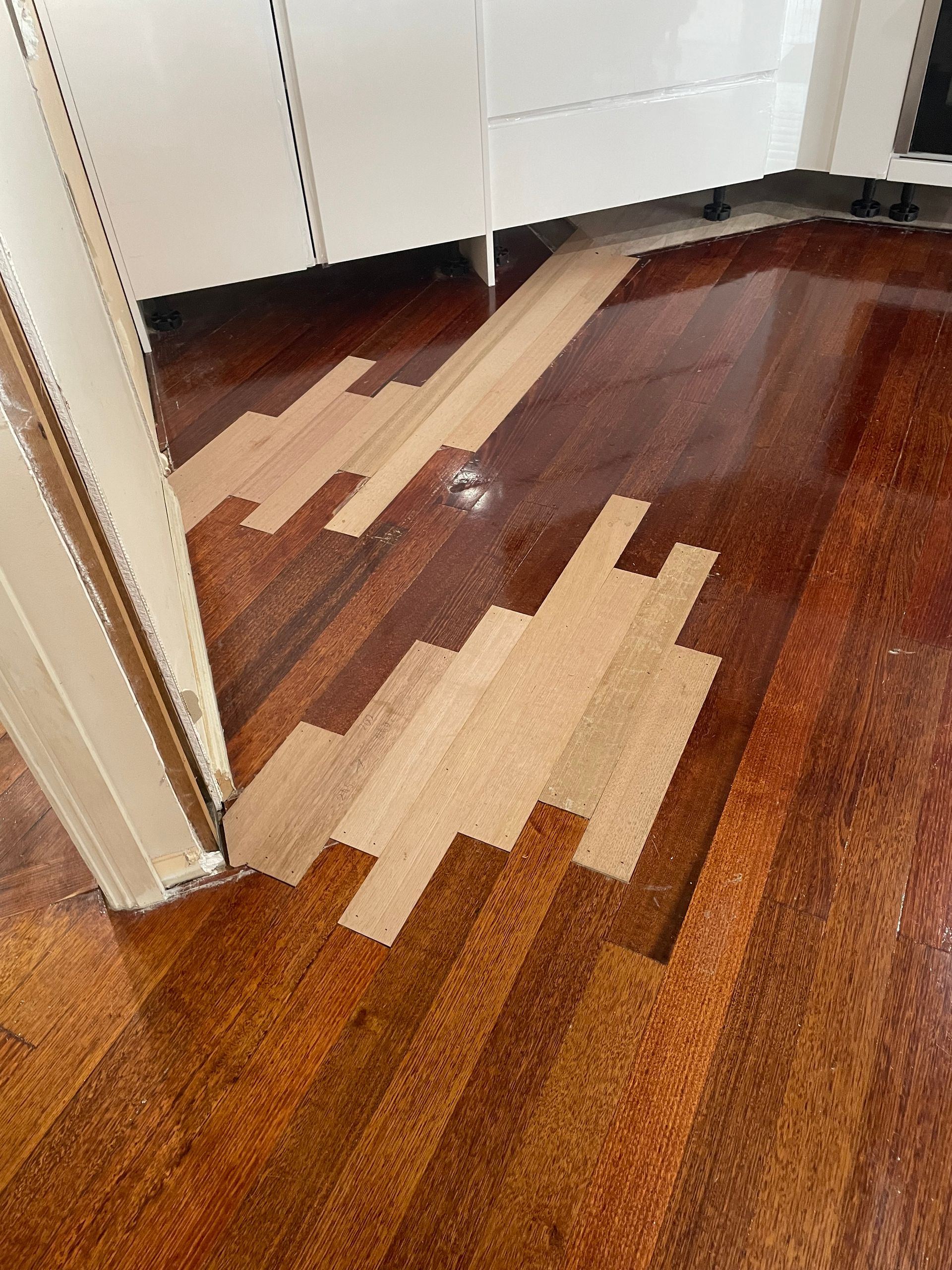 Partially removed wood floor with exposed light underlayment in a hallway — Finer Floors In Cambridge, TAS