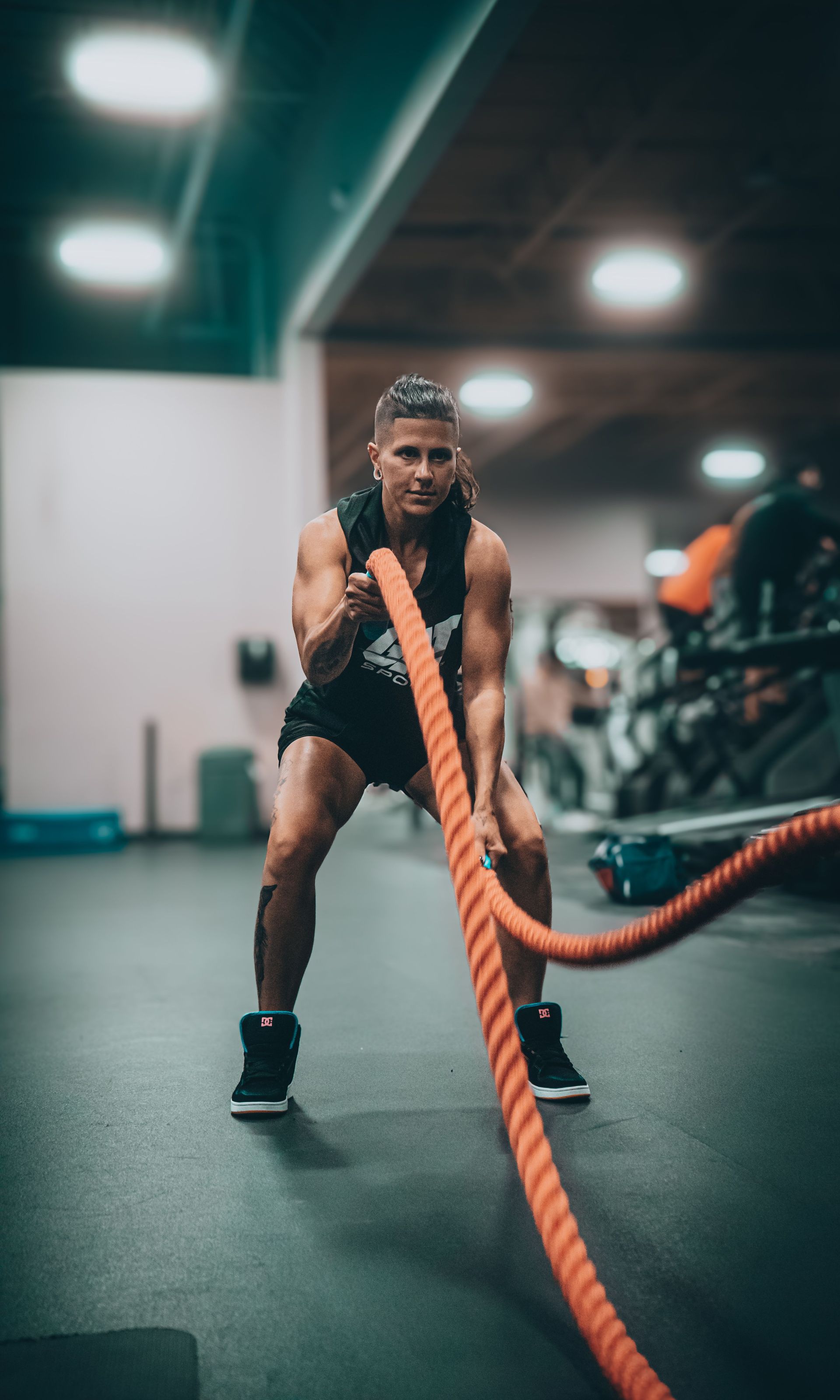 Athlete pulling thick battle ropes in a gym, focused during a workout.