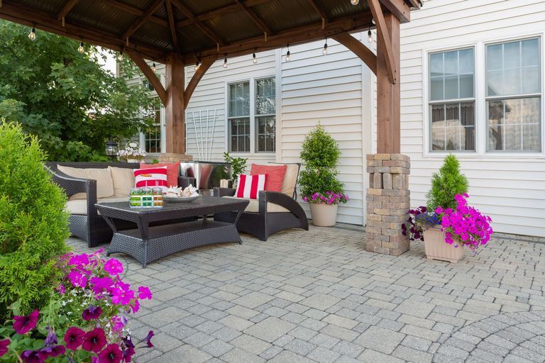 A patio with furniture and flowers.