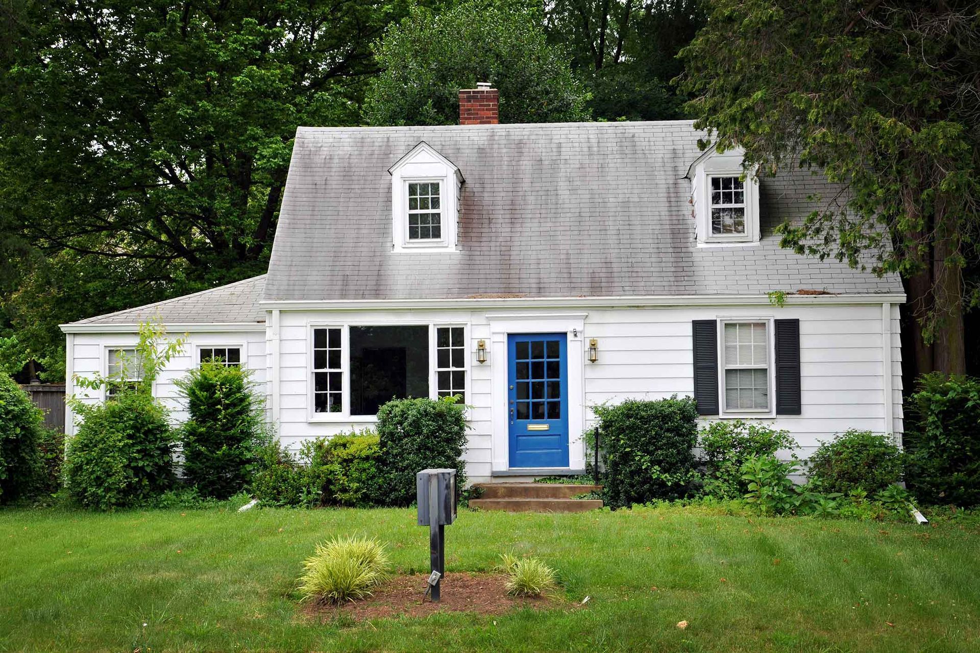 A white house with a blue door and black shutters