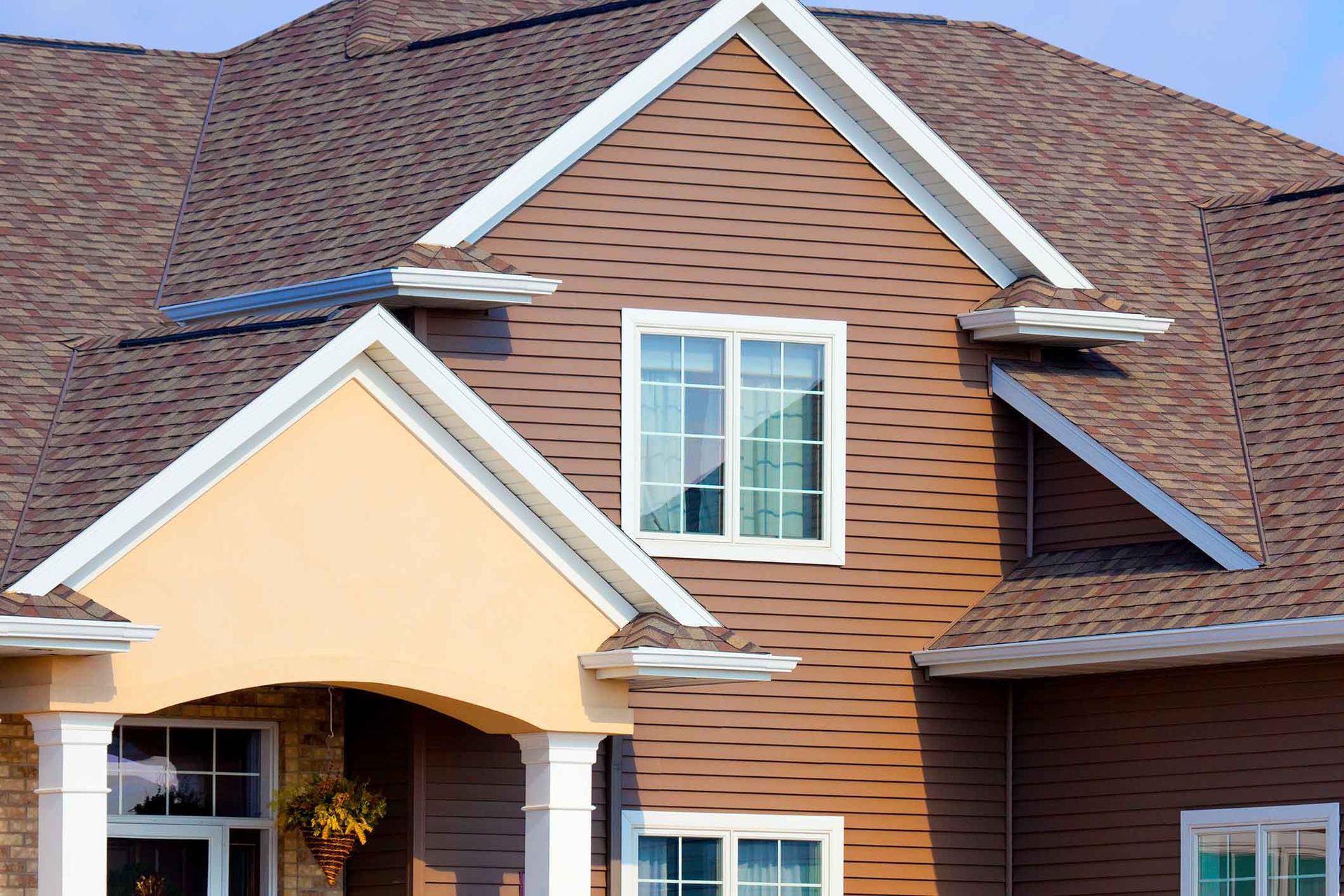 A house with a brown roof and white trim