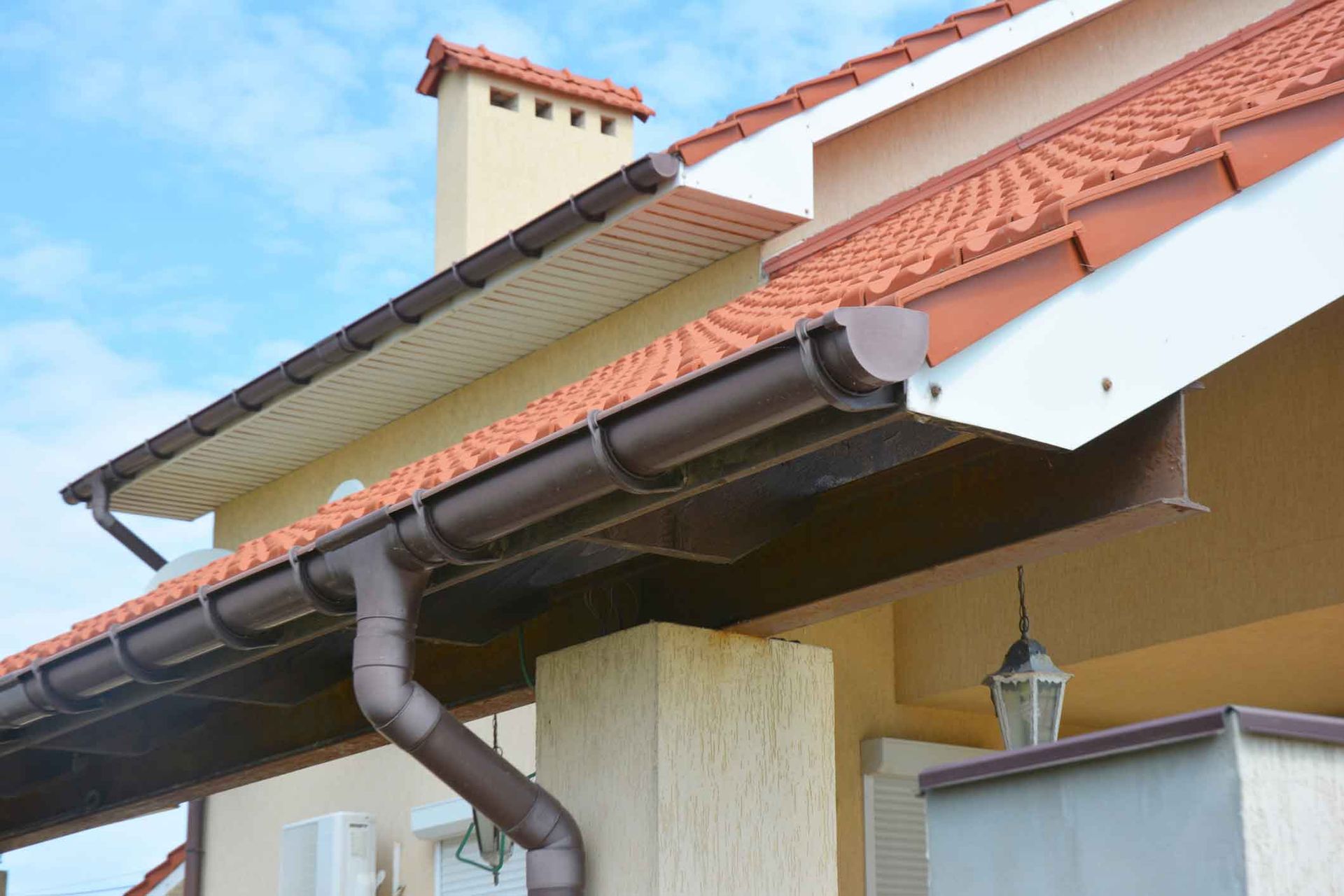 A house with a brown gutter on the side of it.