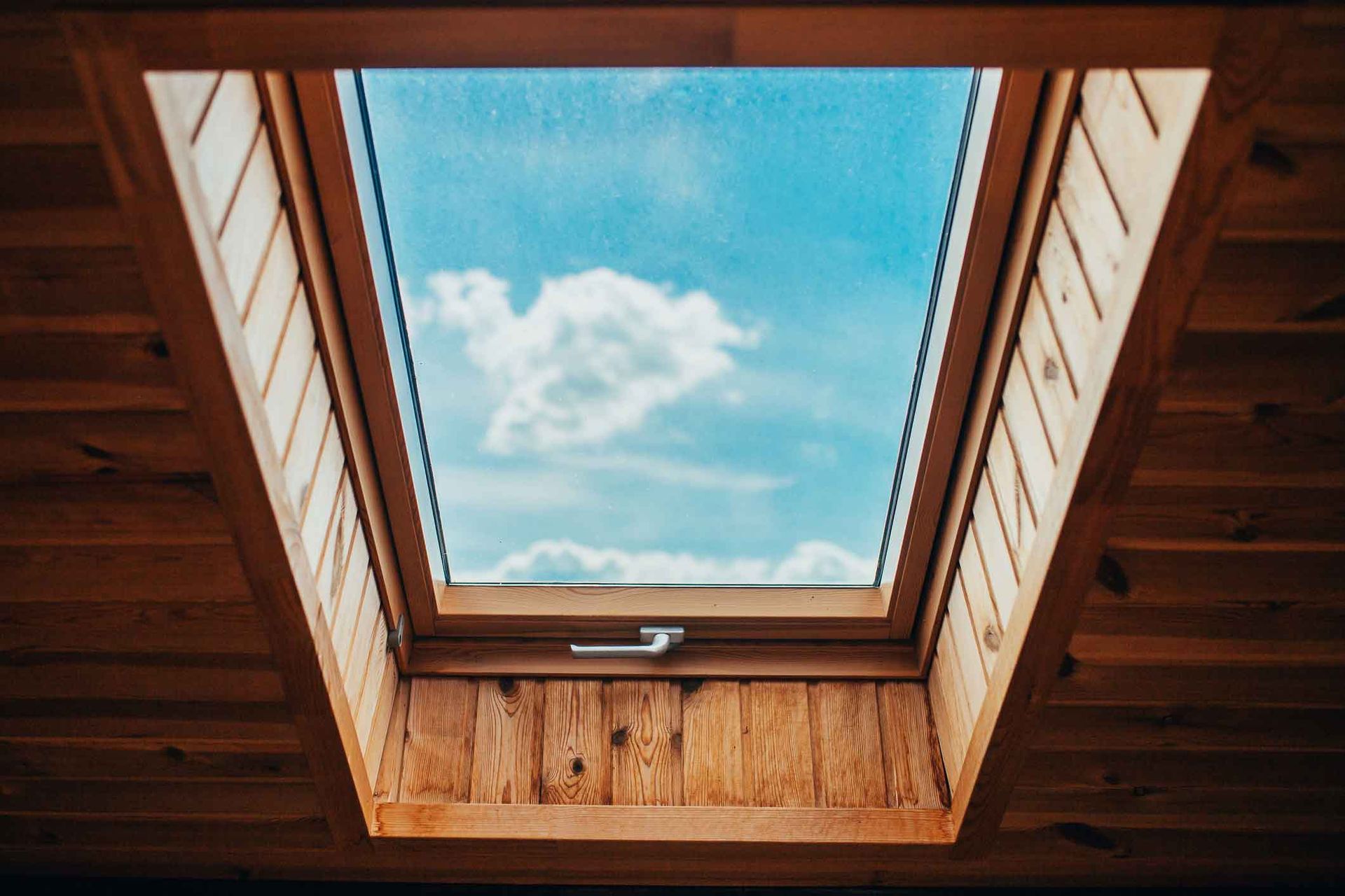 A skylight with a blue sky and clouds visible through it.