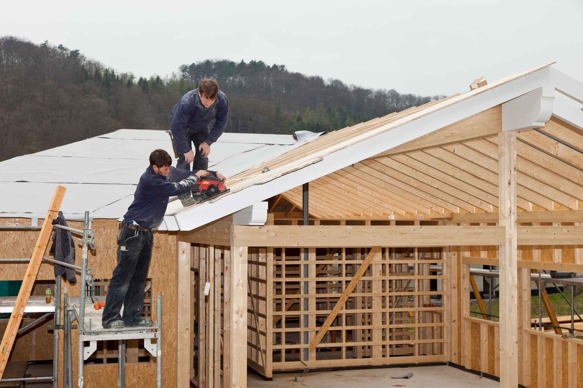 Two men are working on the roof of a building